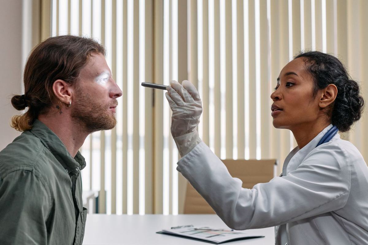 A clinician examining a patient's face